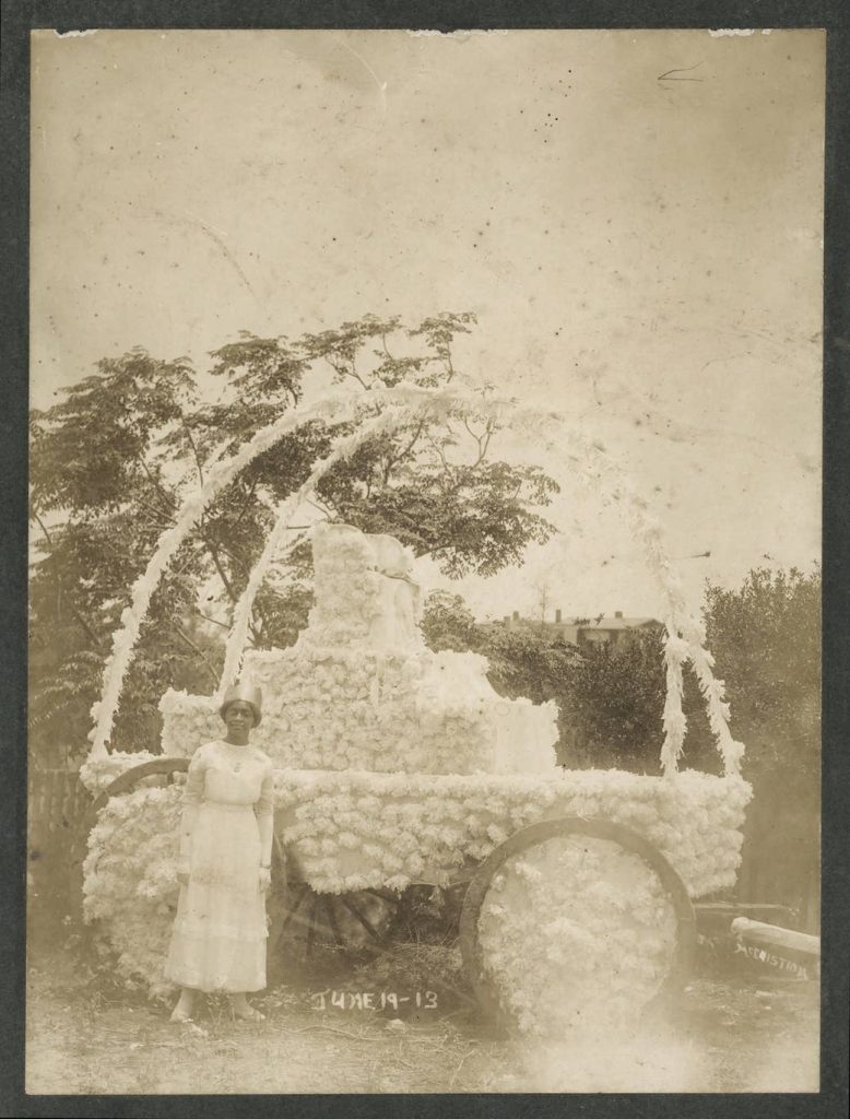 A woman stands before a decorated carriage during a Juneteenth celebration in Texas