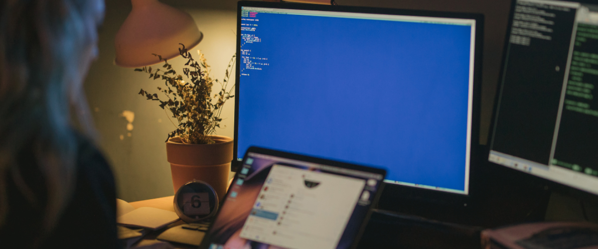 A woman sitting in front of her computer working on her cybersecurity degree with CIAT